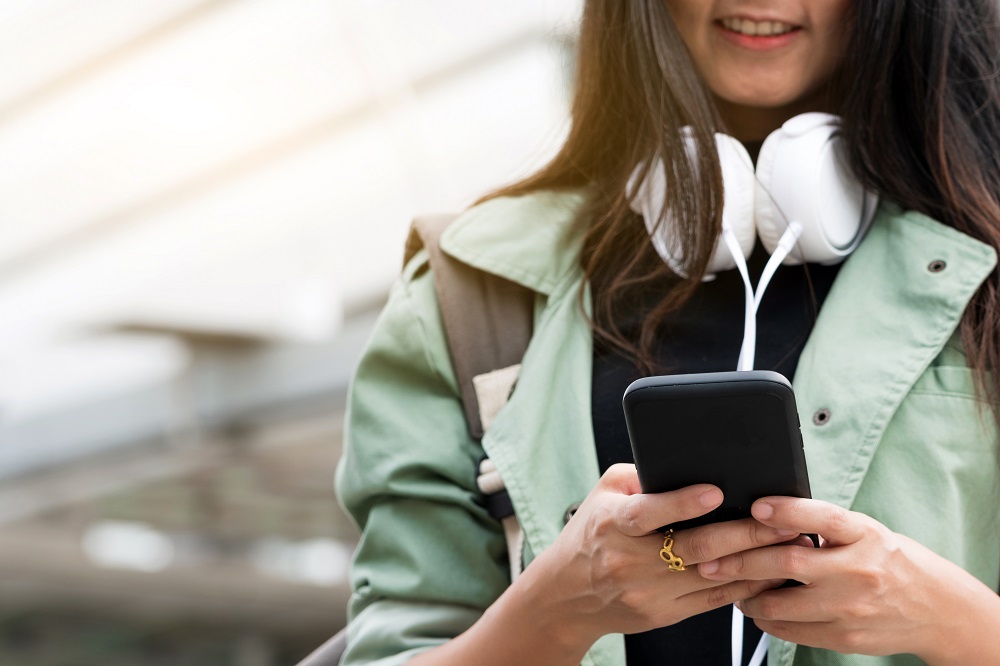A girl with headphones smiling and listening to music.
